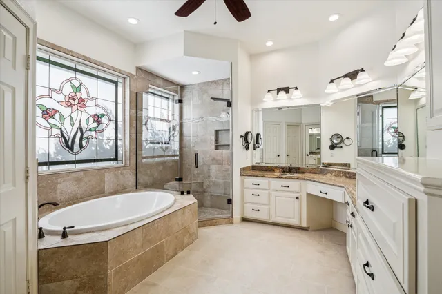 a spacious bathroom with a granite countertop tub sink shower double vanity