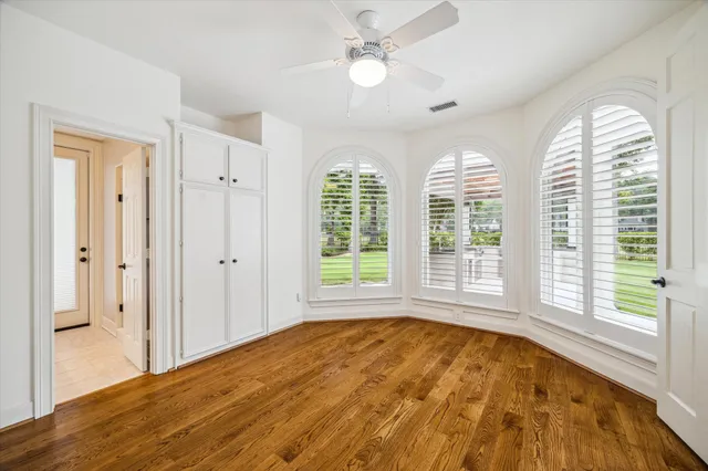 a view of an empty room with a window and a kitchen