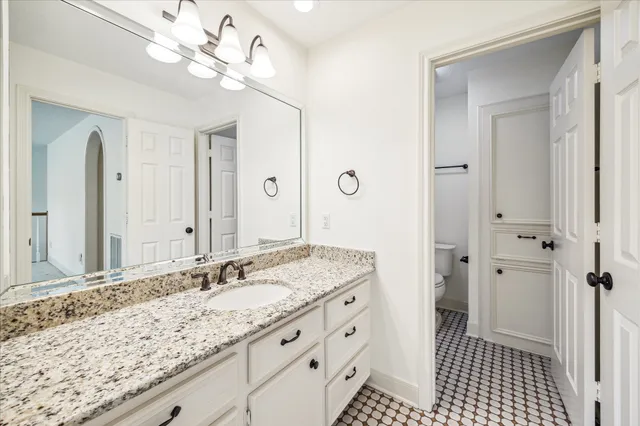 a bathroom with a granite countertop sink a mirror and a shower