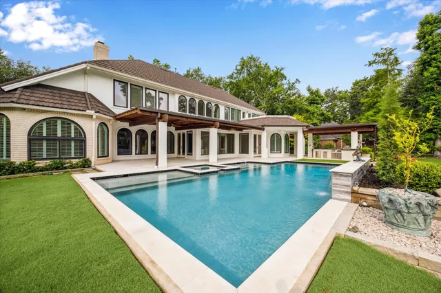 a view of a patio with couches plants and large trees