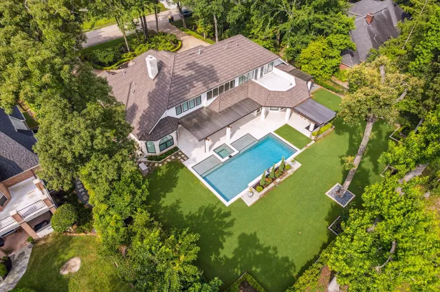 an aerial view of residential houses with outdoor space and trees