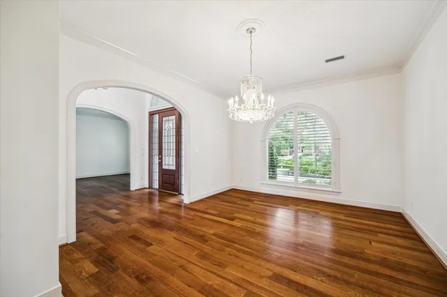 a view of a room with wooden floor chandelier and a window