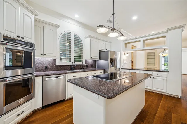 a kitchen with stainless steel appliances granite countertop a stove a sink and a refrigerator