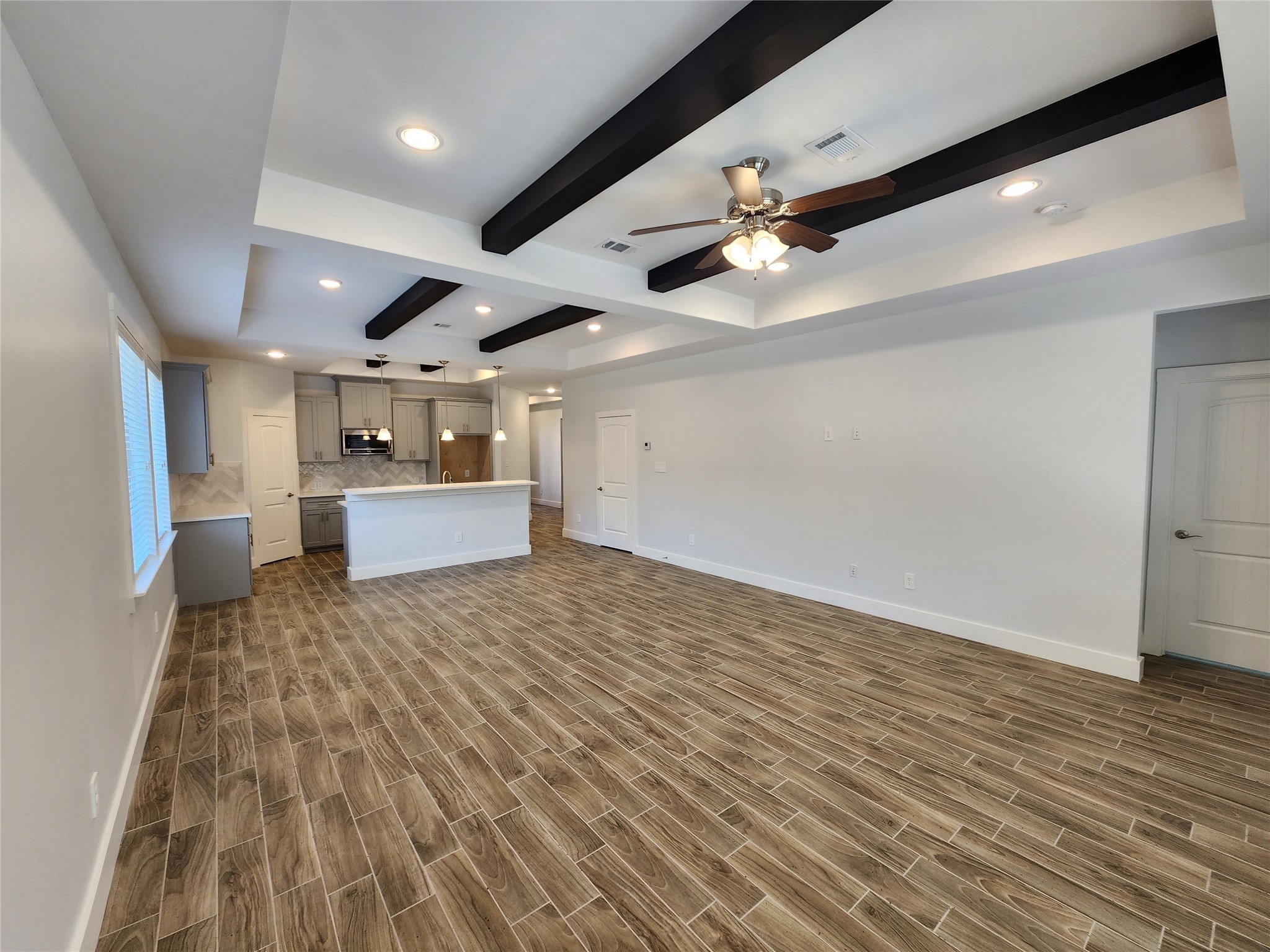 25982 Lantern Lane New Caney, TX 77357 - Photo 14 of 26 a big room with wooden floor a ceiling fan and kitchen space