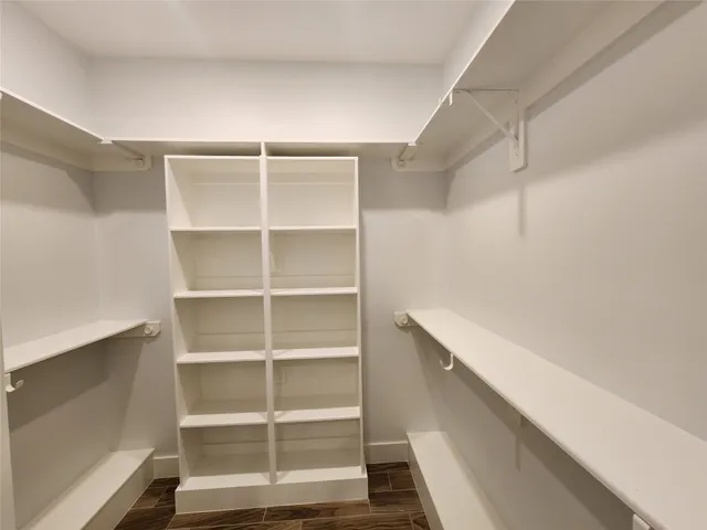 a view of walk in closet with empty racks