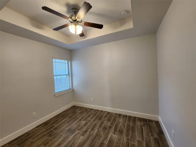 an empty room with a window and a fan