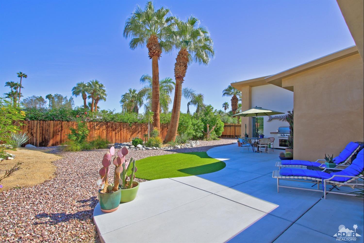 71728 Tunis Road Rancho Mirage, CA 92270 - Photo 32 of 44 a view of a backyard with couches table and chairs under an umbrella
