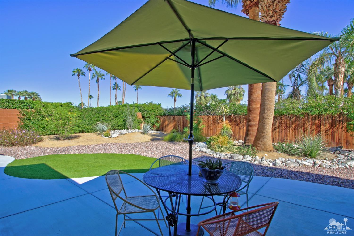 71728 Tunis Road Rancho Mirage, CA 92270 - Photo 36 of 44 a view of an outdoor sitting area with golf table and chair under an umbrella