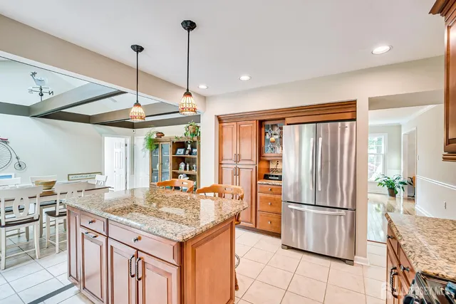 a kitchen with stainless steel appliances granite countertop a refrigerator a sink a stove and island