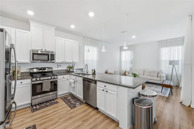 a kitchen with stainless steel appliances granite countertop a sink stove and refrigerator