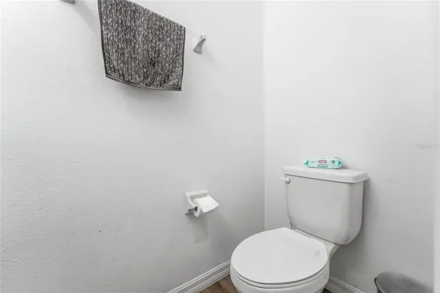 a white toilet sitting next to a white wall