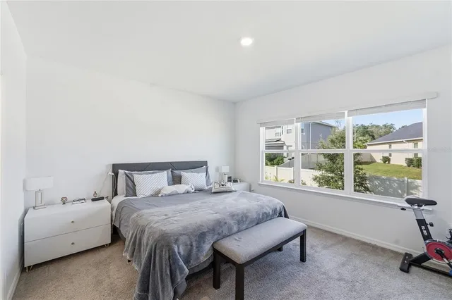 a bedroom with a bed and a large window