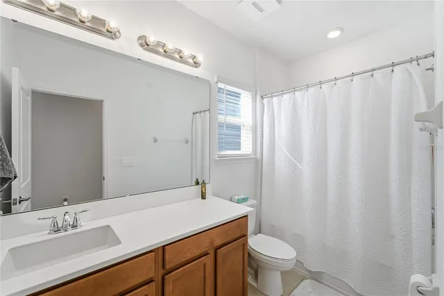 a bathroom with a sink a toilet and shower curtain