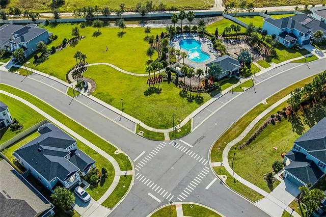 an aerial view of a swimming pool with outdoor seating and yard
