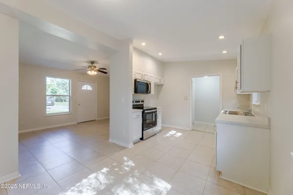 a kitchen with kitchen island granite countertop a sink cabinets and stainless steel appliances