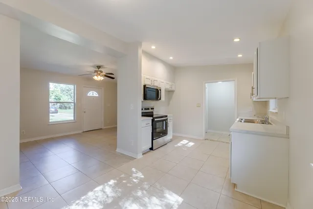a kitchen with kitchen island granite countertop a sink cabinets and stainless steel appliances