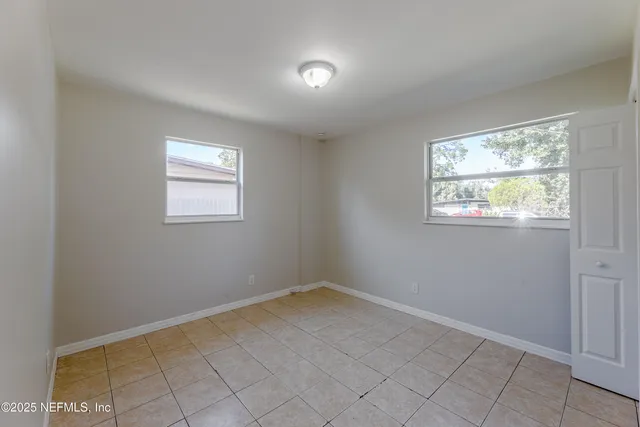 an empty room with windows and closet