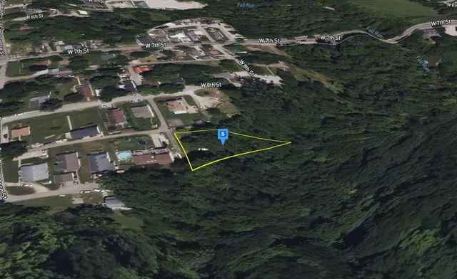 an aerial view of residential houses with outdoor space and trees