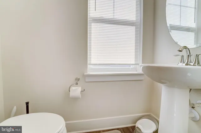 a bathroom with a sink a toilet and a window