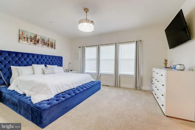 a spacious bedroom with a bed and a flat screen tv