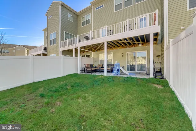 a living room with patio furniture and a garden