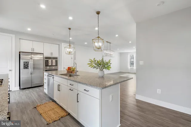 a kitchen with granite countertop white cabinets and white appliances