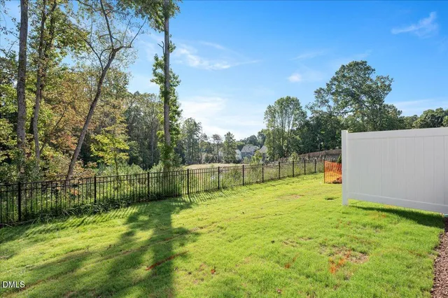 a kitchen with stainless steel appliances granite countertop a refrigerator a sink dishwasher a stove and white cabinets with wooden floor