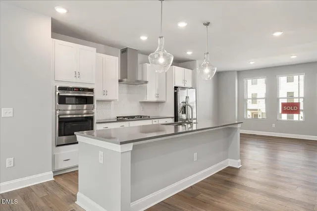 a kitchen with center island a sink stainless steel appliances and cabinets