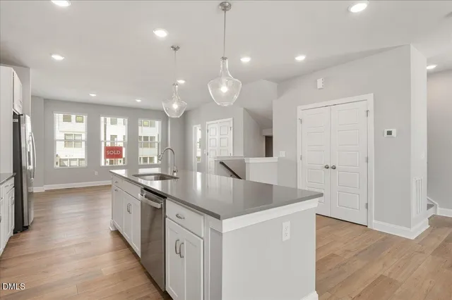 a kitchen with stainless steel appliances granite countertop a sink a oven a dining table and chairs