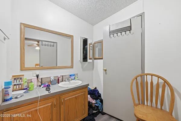 a bathroom with a granite countertop sink a toilet and shower curtain