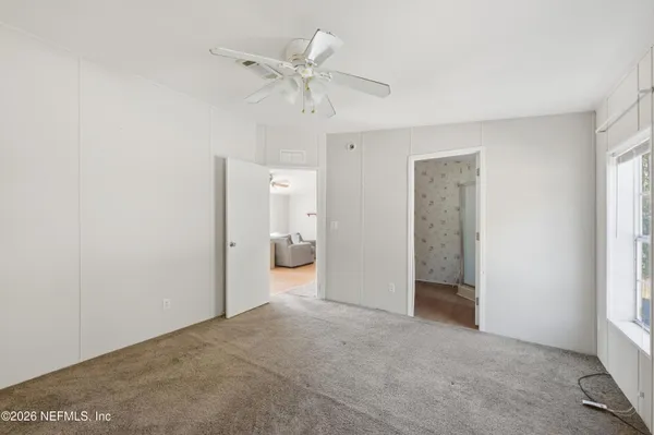a view of a room with a stylish ceiling fan and entryway