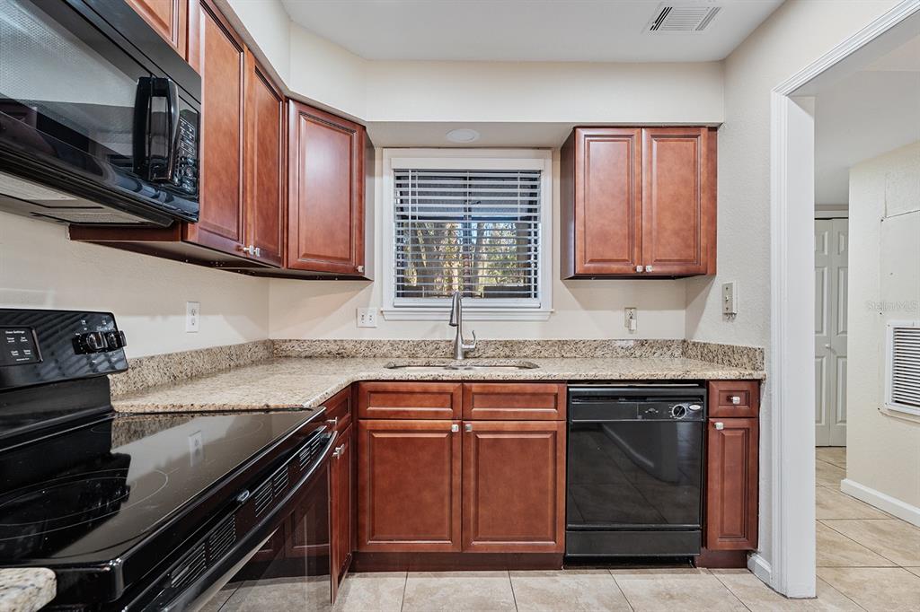 940 Douglas Avenue, Unit 158 Altamonte Springs, FL 32714 - Photo 7 of 23 a kitchen with stainless steel appliances granite countertop a stove and a microwave