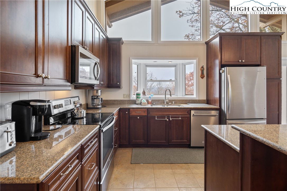 501 St Andrews Road Beech Mountain, NC 28604 - Photo 12 of 46 a kitchen with stainless steel appliances granite countertop a refrigerator a stove and a sink