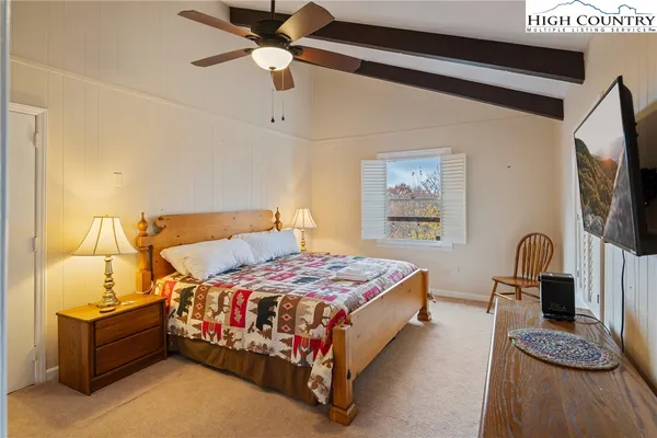 a bedroom with a bed and dresser with mirror