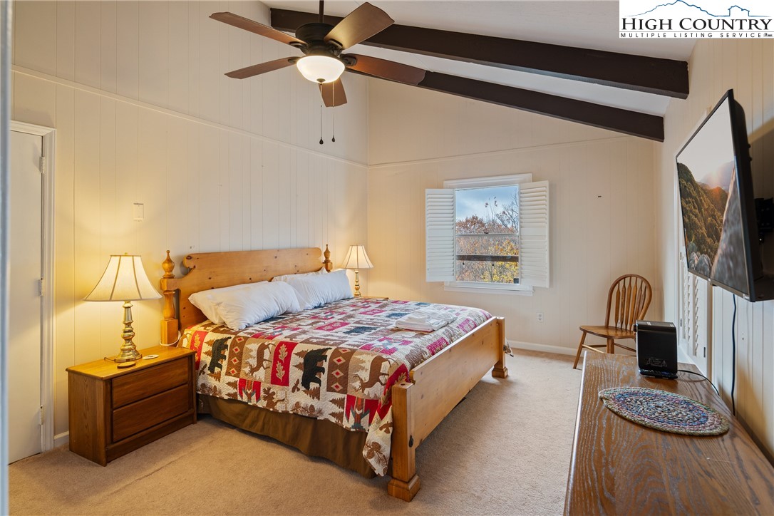 501 St Andrews Road Beech Mountain, NC 28604 - Photo 13 of 46 a bedroom with a bed couch and a flat tv screen