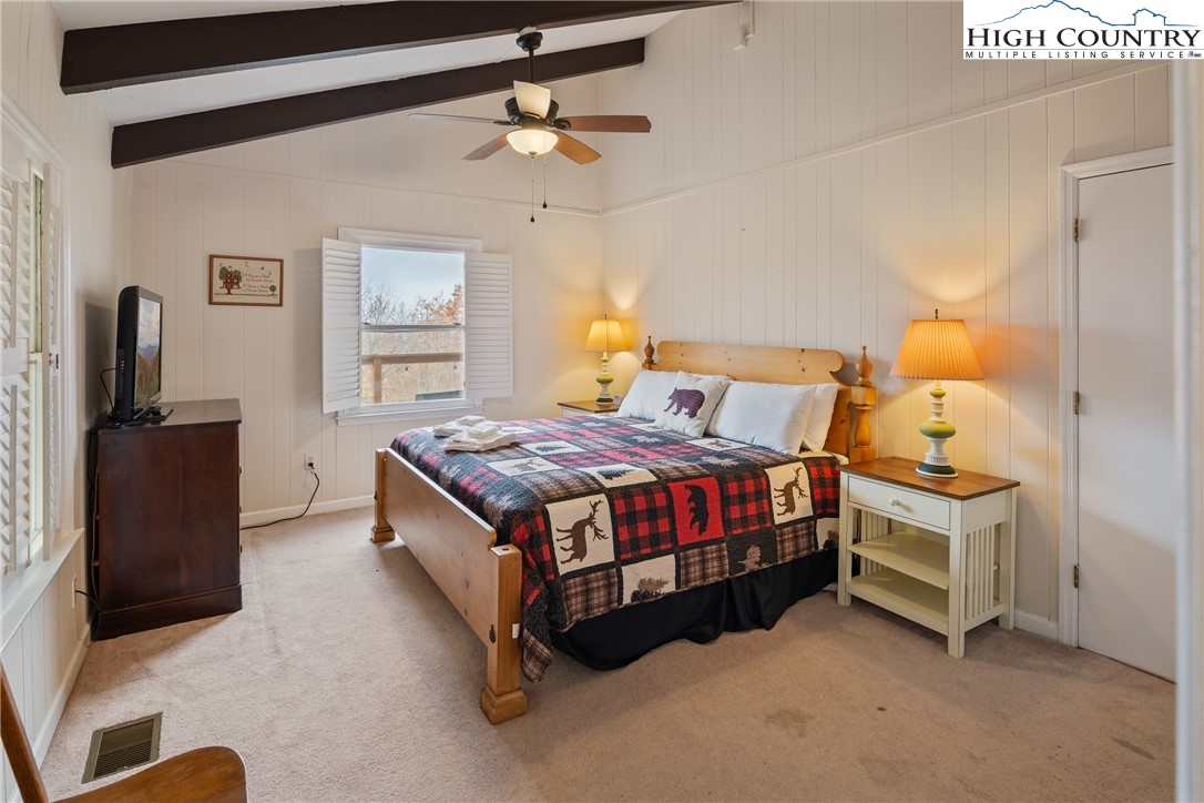 501 St Andrews Road Beech Mountain, NC 28604 - Photo 14 of 46 a bedroom with a bed and dresser with mirror