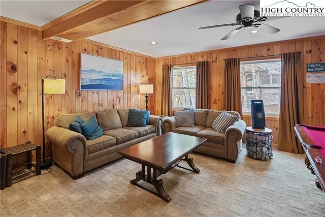 a living room with furniture pool table and a large window