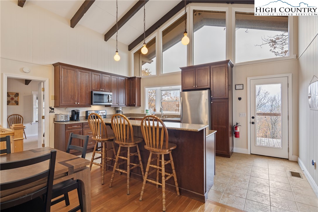 501 St Andrews Road Beech Mountain, NC 28604 - Photo 10 of 46 a kitchen with stainless steel appliances granite countertop a dining table chairs refrigerator and sink