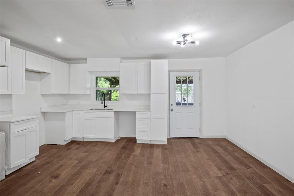 121 Circle Drive Bogata, TX 75417 - Photo 5 of 14 a view of a kitchen with wooden floor and a window