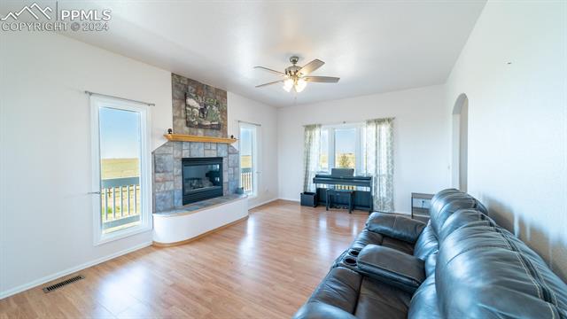 11125 Eureka Road Calhan, CO 80808 - Photo 15 of 44 Living room with a fireplace, ceiling fan, and hardwood / wood-style floors