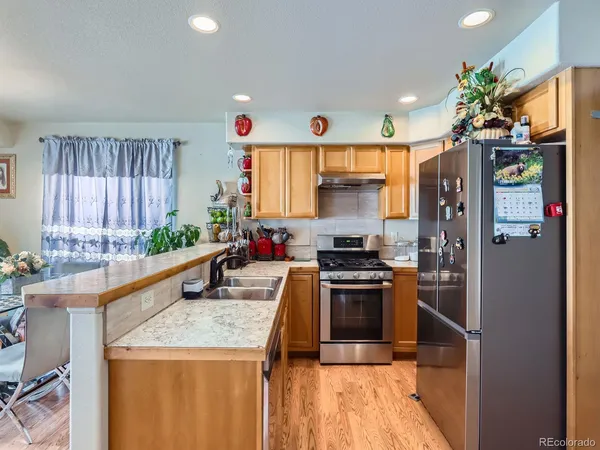 a kitchen with stainless steel appliances granite countertop a sink stove and cabinets