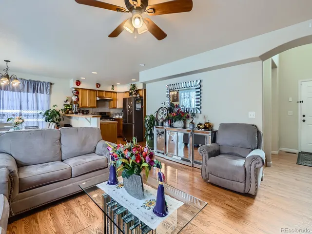 a living room with furniture kitchen view and a large window