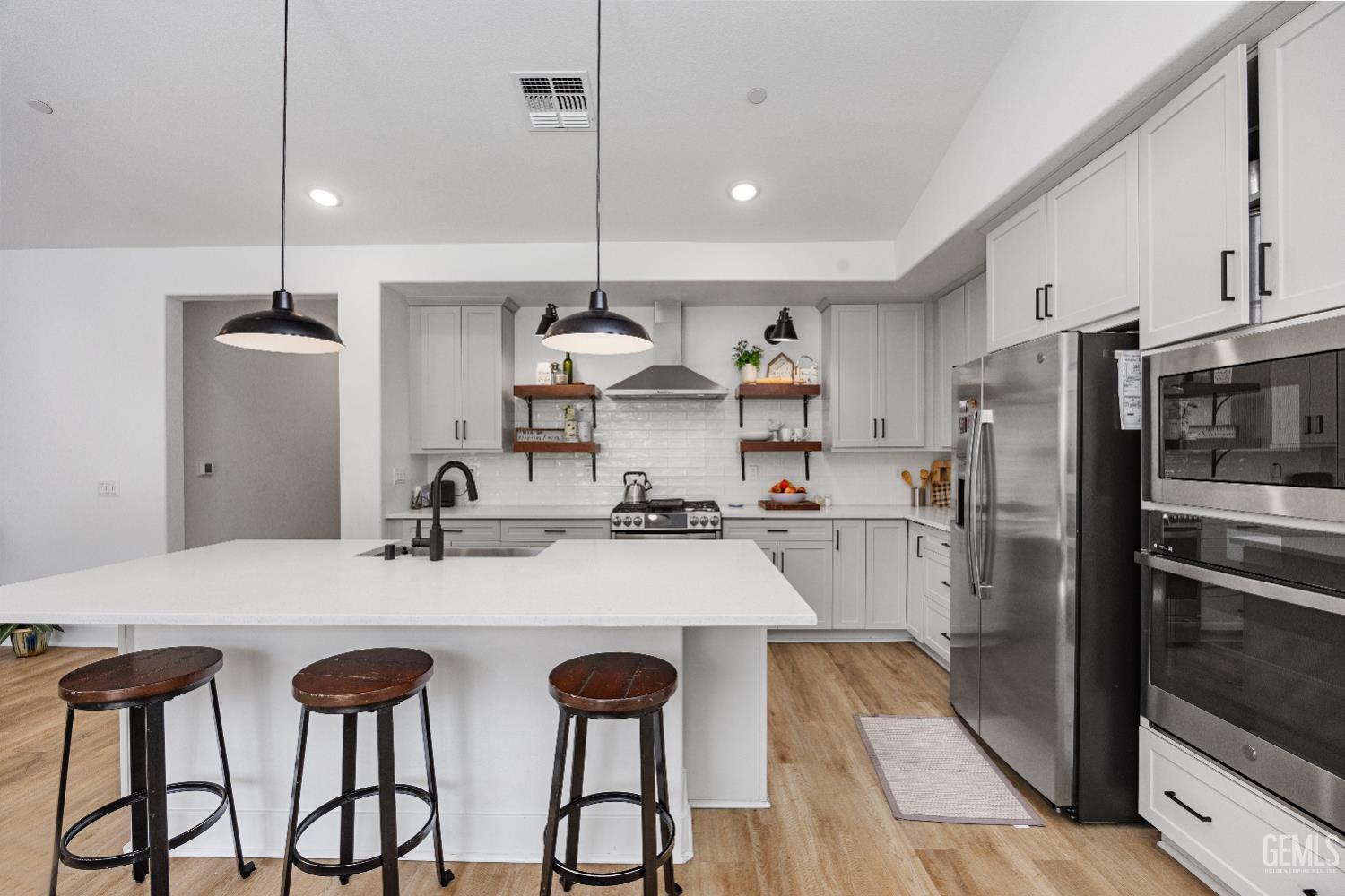 Undisclosed Address Tehachapi, CA 93561 - Photo 21 of 49 a kitchen with stainless steel appliances kitchen island a refrigerator and a stove top oven