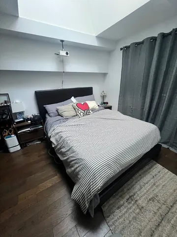 a bedroom with bed and wooden floor