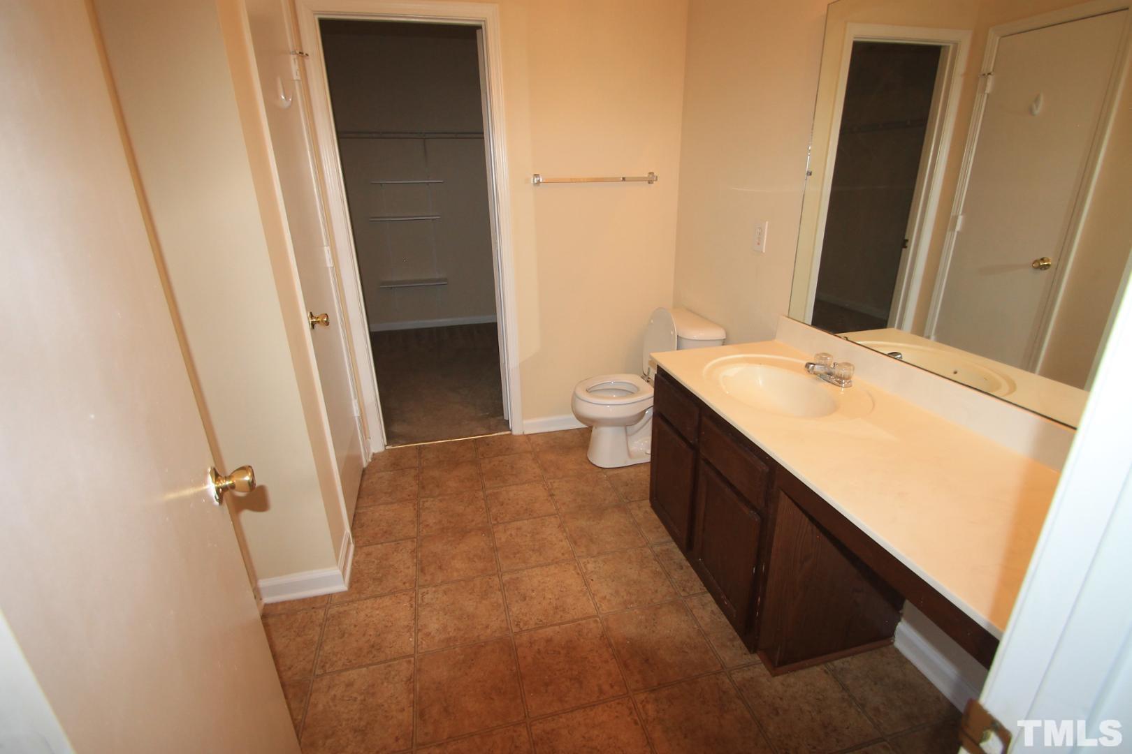 408 Pebblestone Drive Durham, NC 27703 - Photo 19 of 27 a bathroom with a sink a toilet and a mirror