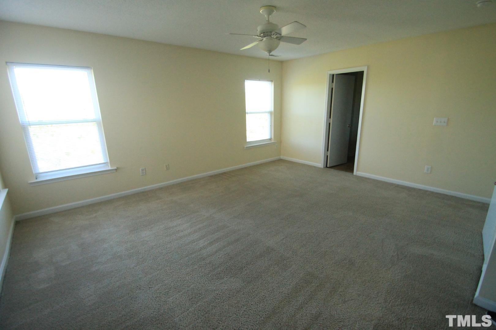 408 Pebblestone Drive Durham, NC 27703 - Photo 22 of 27 an empty room with a window and a chandelier fan