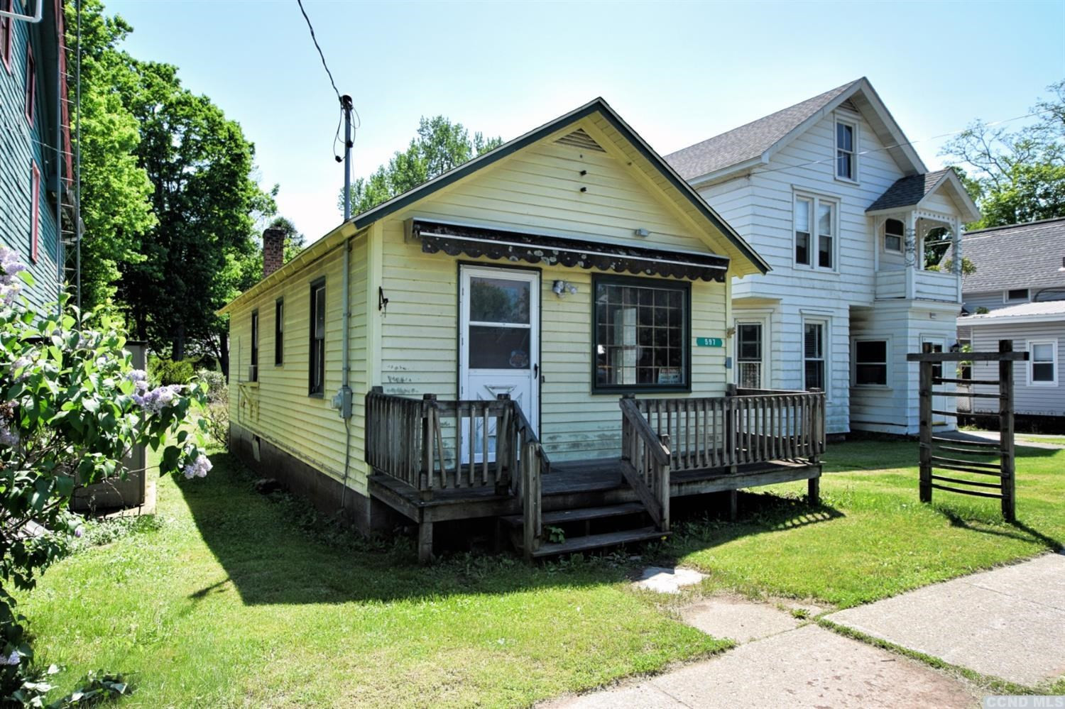 a view of house with a yard chairs and iron fence
