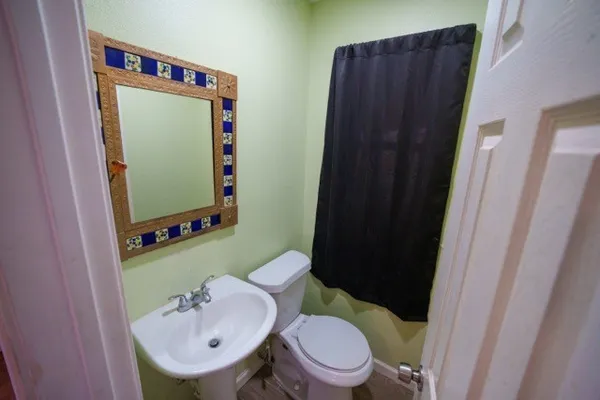 a bathroom with a sink toilet and mirror