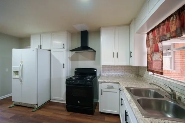 a kitchen with a refrigerator sink and cabinets