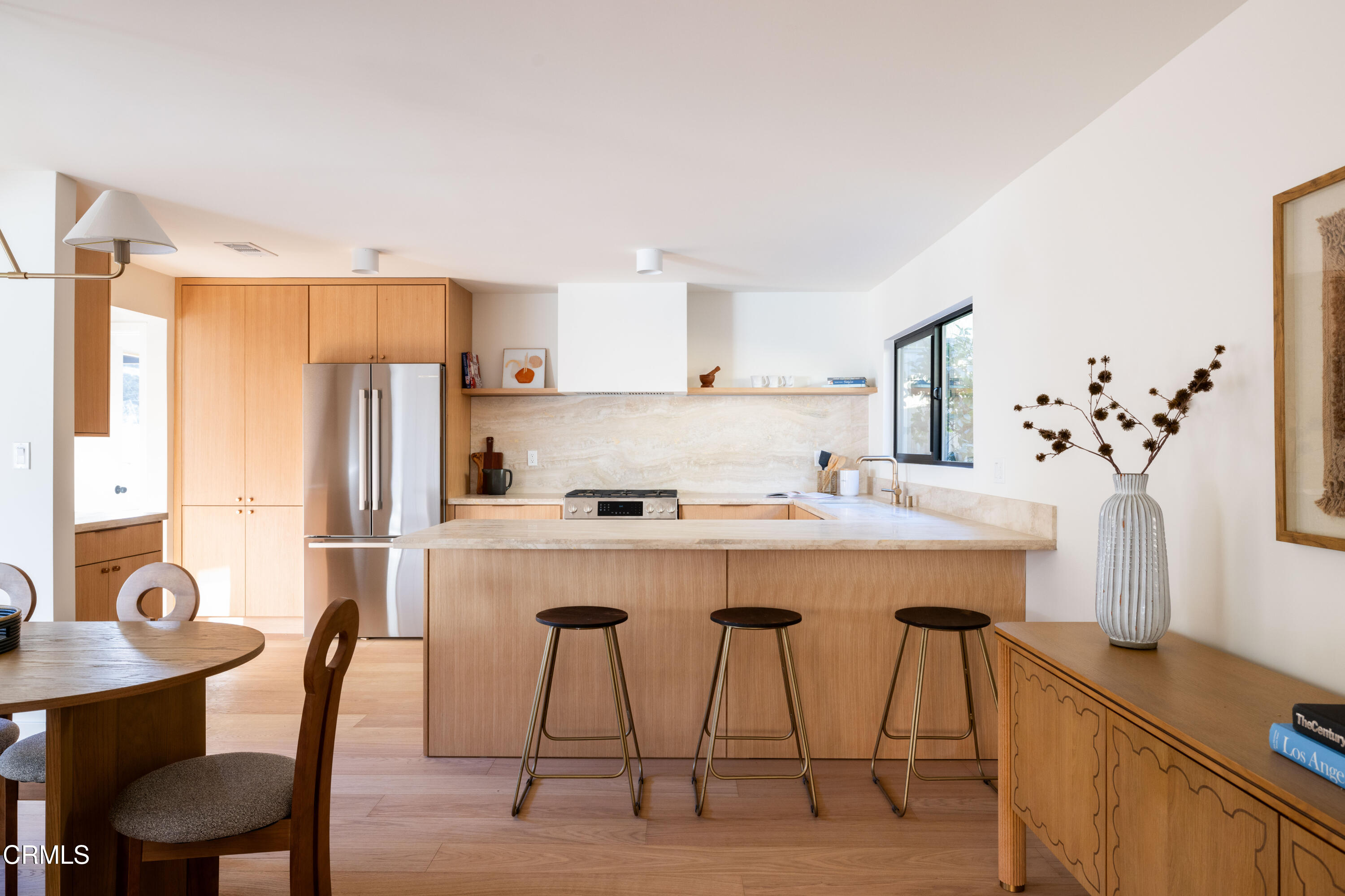 1054 Rutland Avenue Los Angeles, CA 90042 - Photo 7 of 27 a kitchen with stainless steel appliances a dining table chairs a refrigerator and cabinets